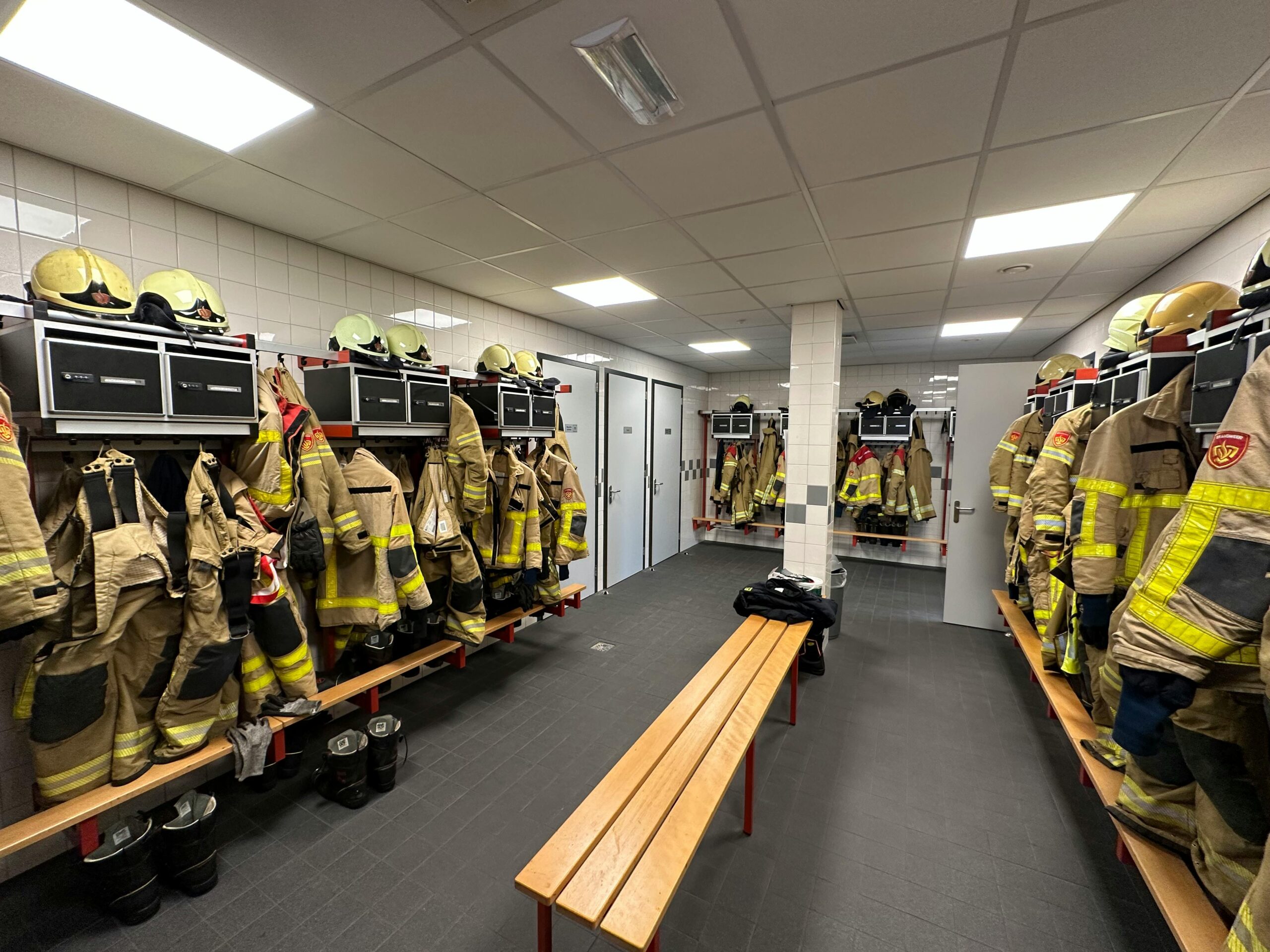 Locker room with firefighter uniforms and equipment in Varsseveld fire station.